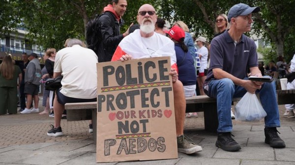 Rival groups face off outside migrant hotel - as asylum seekers 'blow kisses' at protesters Rival groups face off outside migrant hotel - as asylum seekers 'blow kisses' at protesters