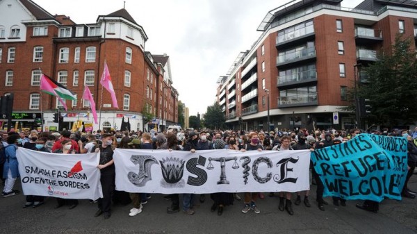 Rival groups face off outside migrant hotel - as asylum seekers 'blow kisses' at protesters Rival groups face off outside migrant hotel - as asylum seekers 'blow kisses' at protesters