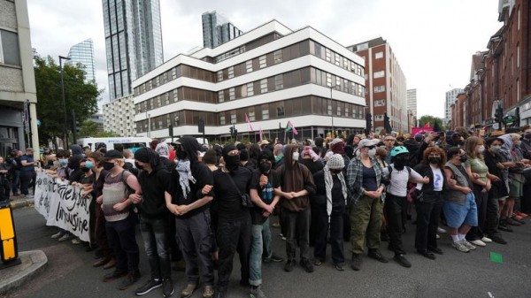 Rival groups face off outside migrant hotel - as asylum seekers 'blow kisses' at protesters Rival groups face off outside migrant hotel - as asylum seekers 'blow kisses' at protesters